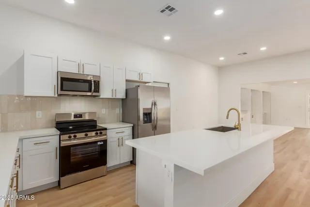 a kitchen with kitchen island a stove sink and microwave