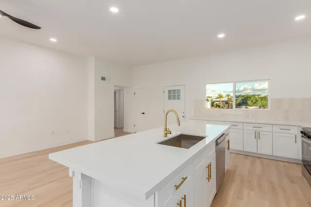 a kitchen with a sink cabinets and wooden floor