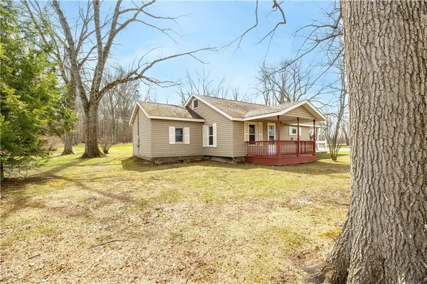 a view of a house with a large tree and wooden fence