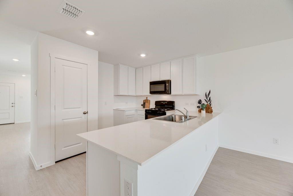 109 Pecan Flts Road Balch Springs, TX 75181 - Photo 19 of 26 a kitchen with a sink a stove cabinets and a refrigerator