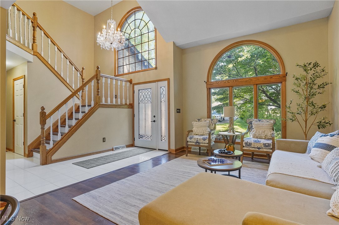 370 Wilcox Road Youngstown, OH 44515 - Photo 2 of 49 Living area featuring a chandelier, wood finished floors, stairway, and a high ceiling