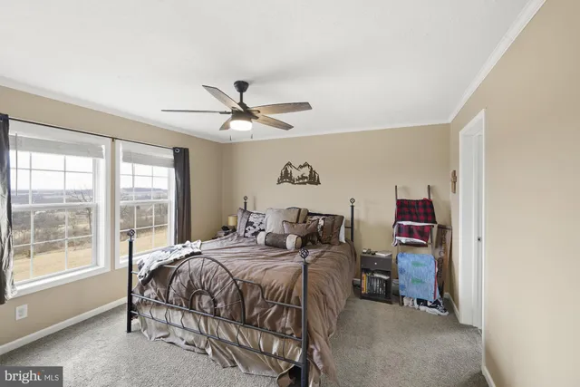 a bedroom with a bed and a large window