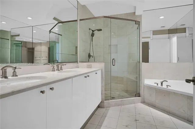 a bathroom with a double vanity sink mirror double shower and a bathtub