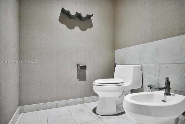 a white toilet sitting next to a bathroom sink