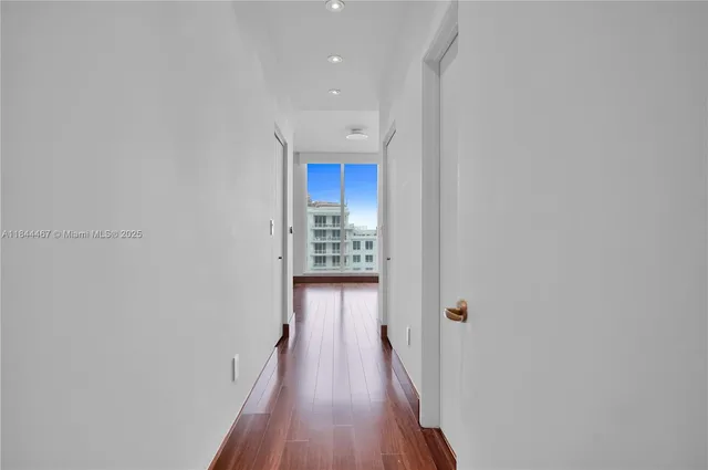 a view of a hallway with wooden floor