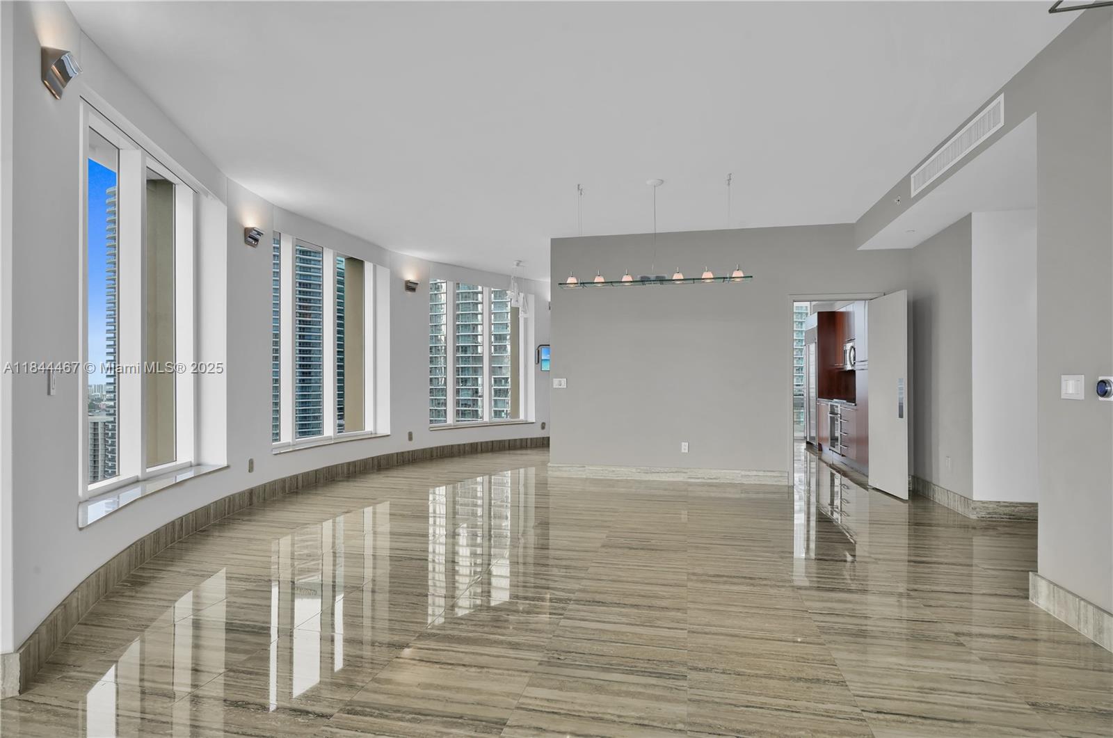 901 Brickell Key Boulevard, Unit 3204 Miami, FL 33131 - Photo 19 of 54 a view of an empty room with wooden floor and a window