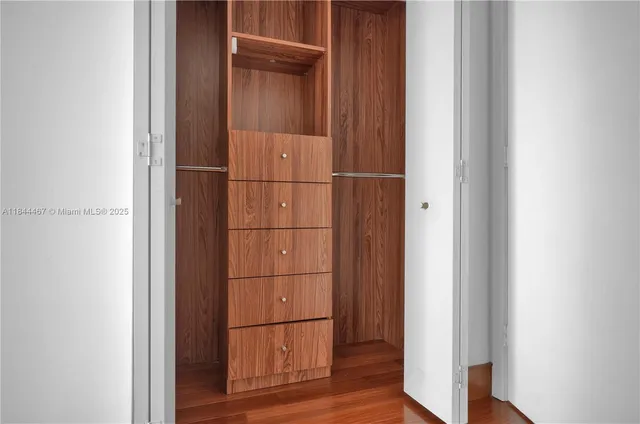 a kitchen with stainless steel appliances wooden cabinets and a wooden floor