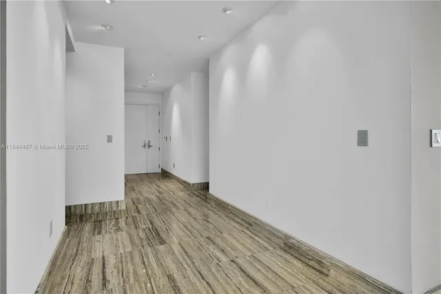 a view of a room with wooden floor and a ceiling fan