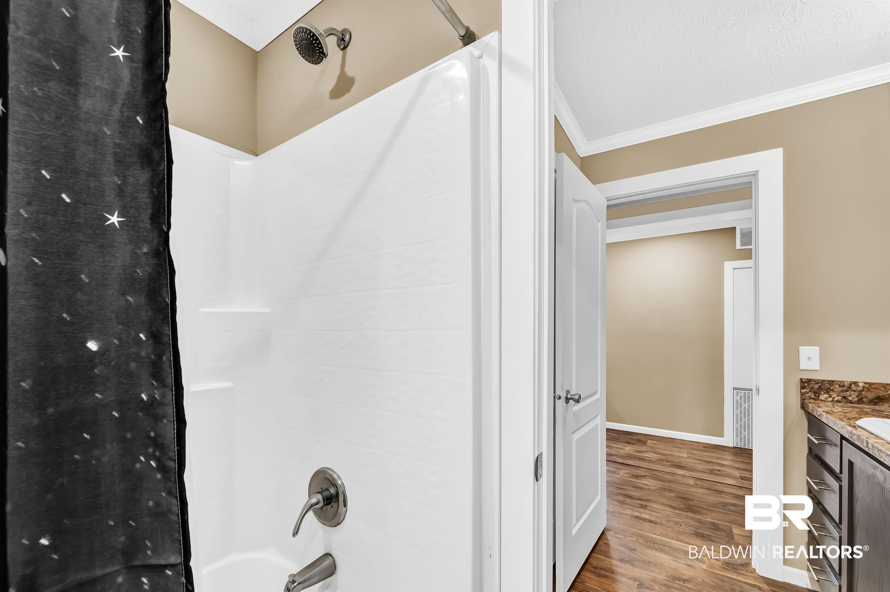 23233 Forland Road Silverhill, AL 36576 - Photo 27 of 33 Full bathroom featuring crown molding, washtub / shower combination, baseboards, wood finished floors, and vanity
