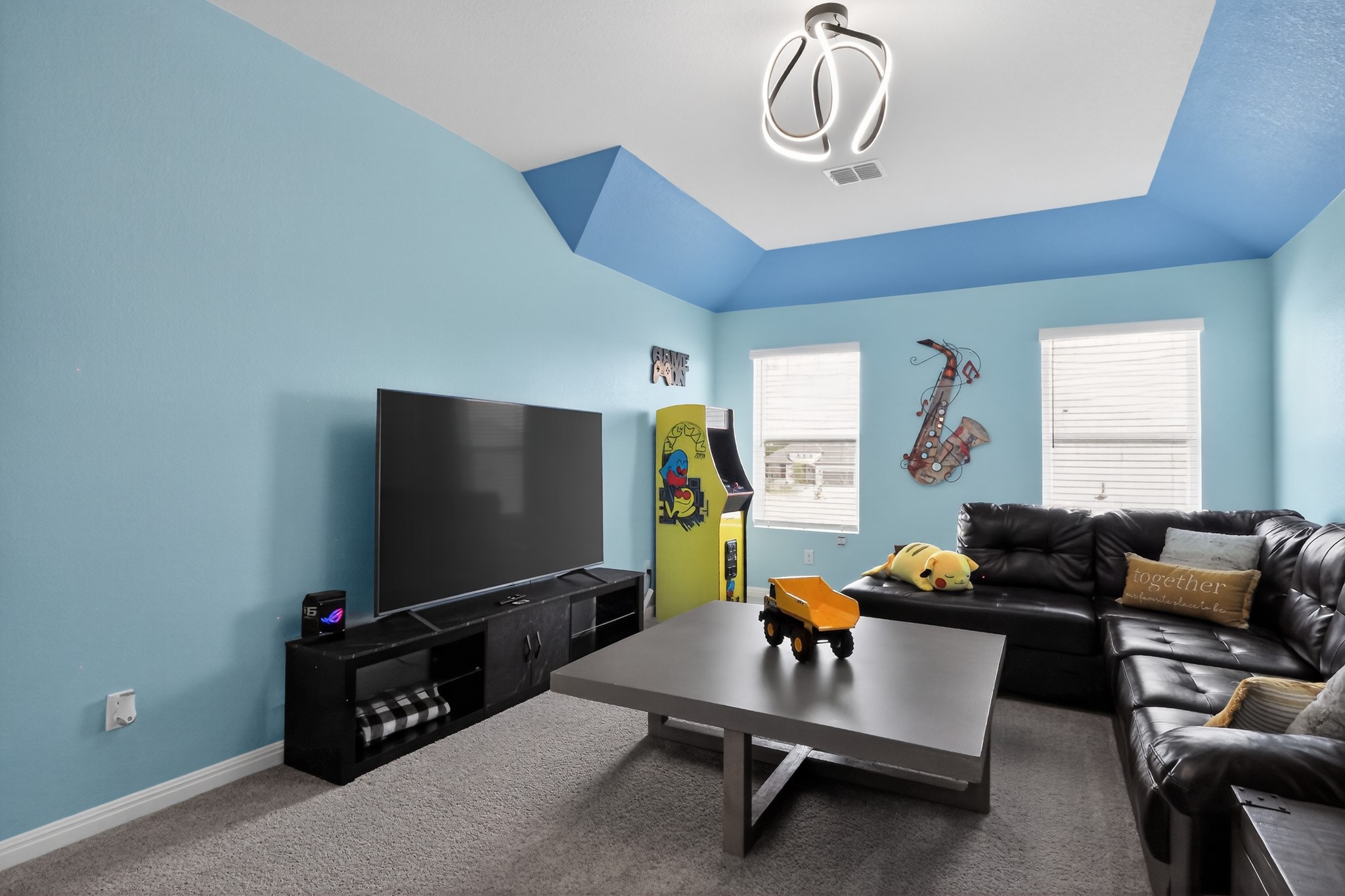 114 Bosco Road Hutto, TX 78634 - Photo 18 of 39 Step into a lively entertainment space, featuring a large screen for media enjoyment and a comfortable sectional sofa.