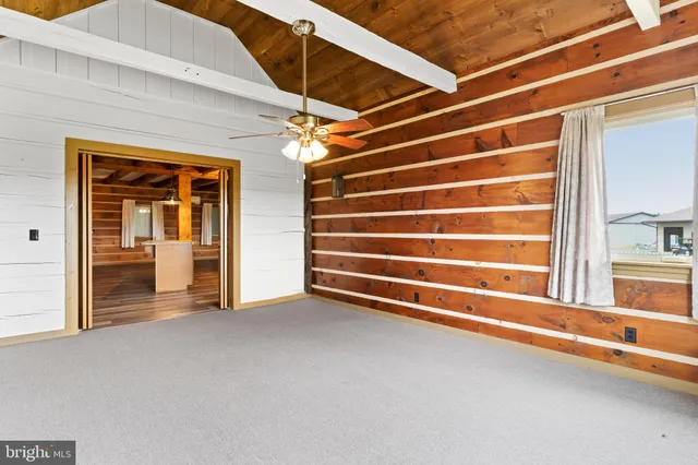 a view of a hallway with wooden floor and furniture