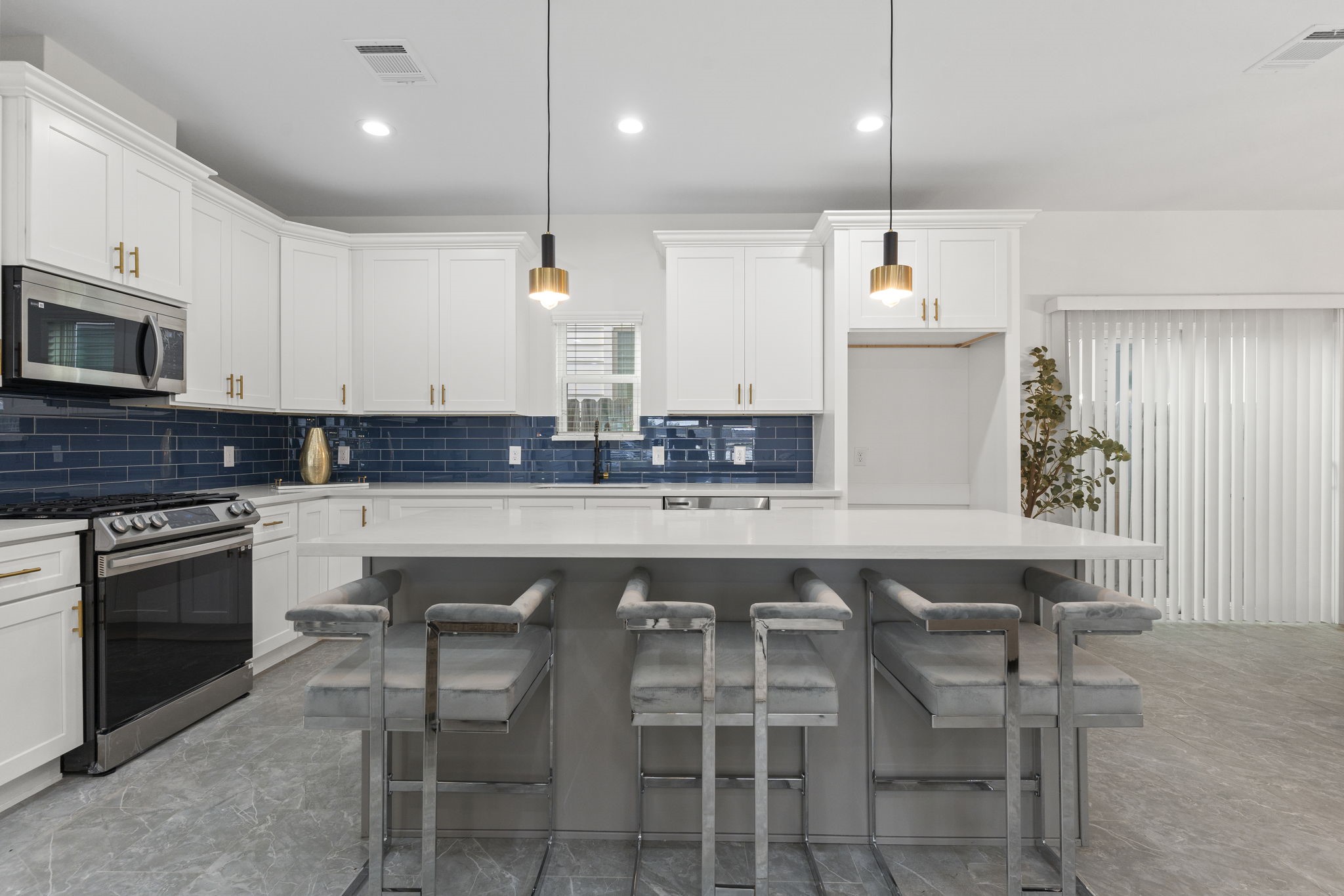 1517 Egypt Street Houston, TX 77009 - Photo 18 of 46 a kitchen with stainless steel appliances a sink a stove a center island and chairs