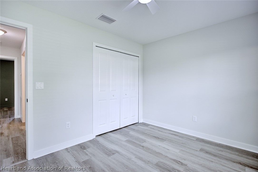111 Vale Court Sebring, FL 33876 - Photo 24 of 40 a view of an empty room with wooden floor