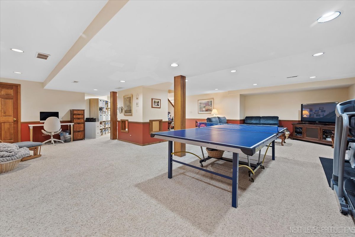 87 Hawkins Circle Wheaton, IL 60189 - Photo 30 of 42 a living room with furniture a table and a flat screen tv