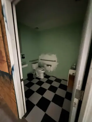 a bathroom with a black and white checkered floor