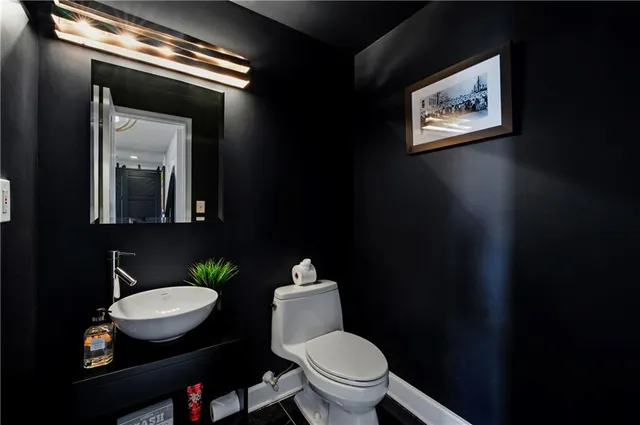 a bathroom with a toilet sink and mirror