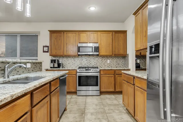 a kitchen with stainless steel appliances granite countertop a sink stove and refrigerator