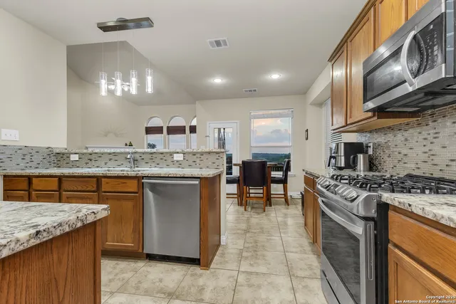 a kitchen with stainless steel appliances granite countertop a stove a sink and a refrigerator