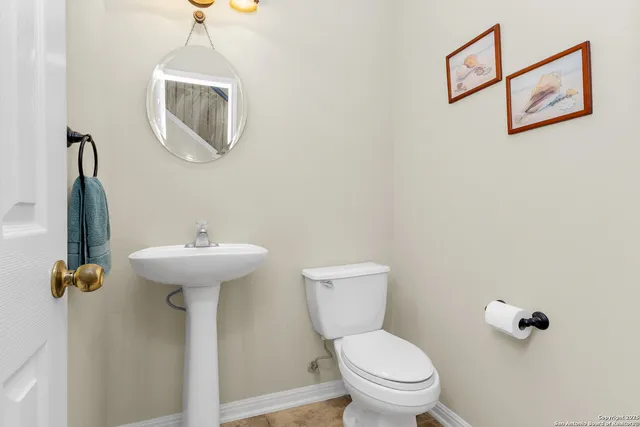 a bathroom with a sink a toilet and a mirror