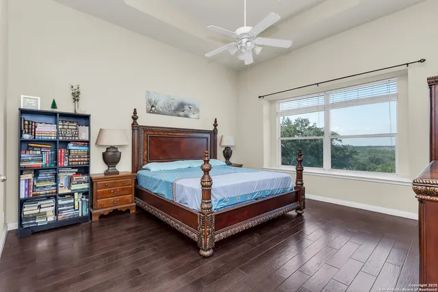 a bedroom with a bed and a large window with wooden floor