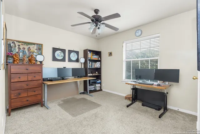 a view of a workspace with furniture and a window