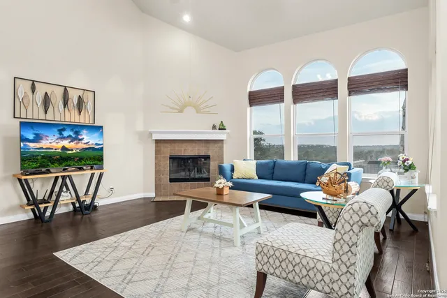 a living room with furniture a flat screen tv and a floor to ceiling window