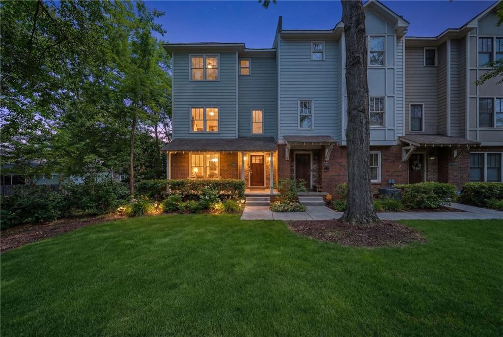 a view of a brick house with a yard and plants