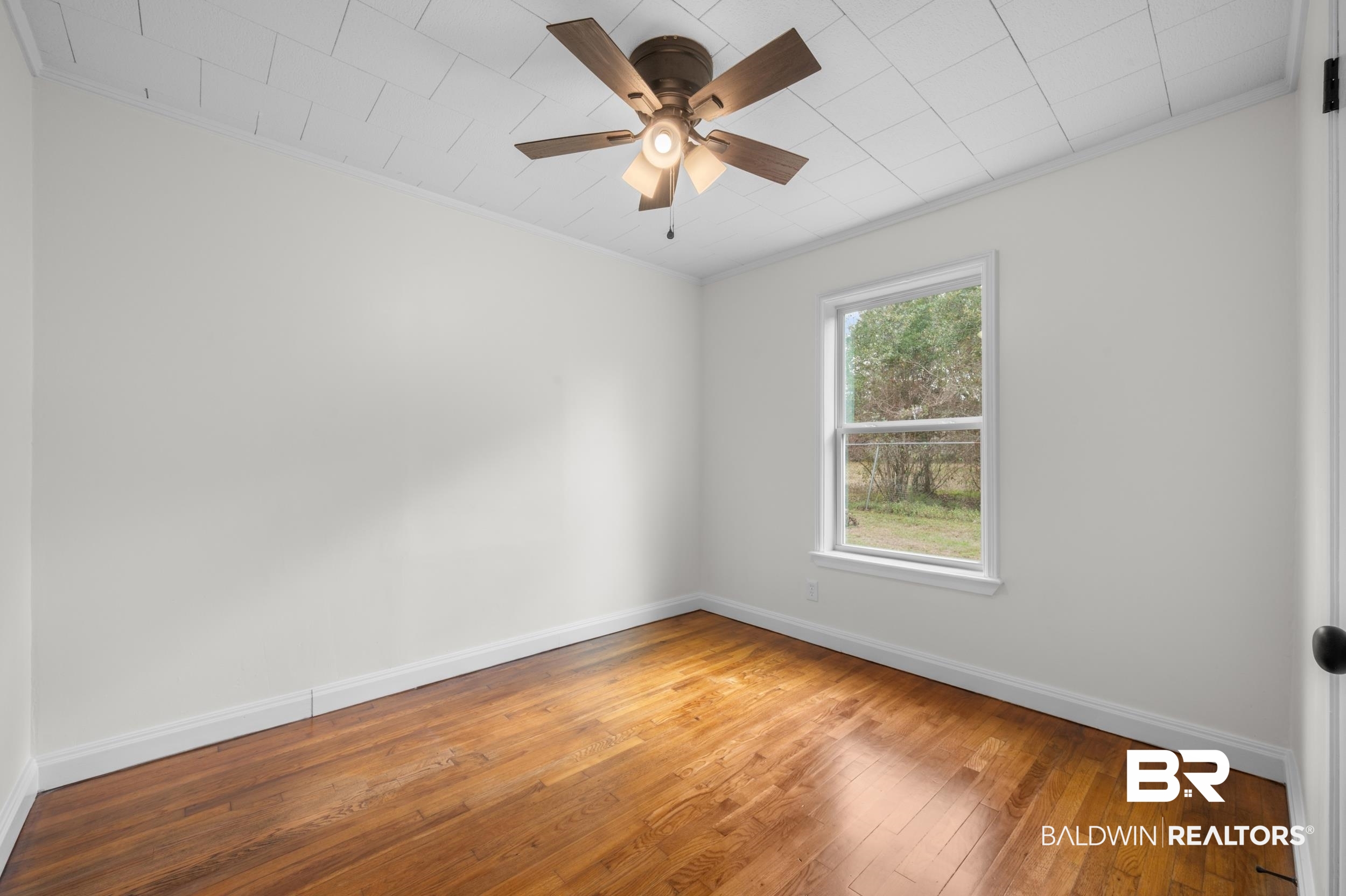 35780 Spring Road North Stapleton, AL 36578 - Photo 24 of 41 Empty room with ornamental molding, light wood finished floors, and a ceiling fan