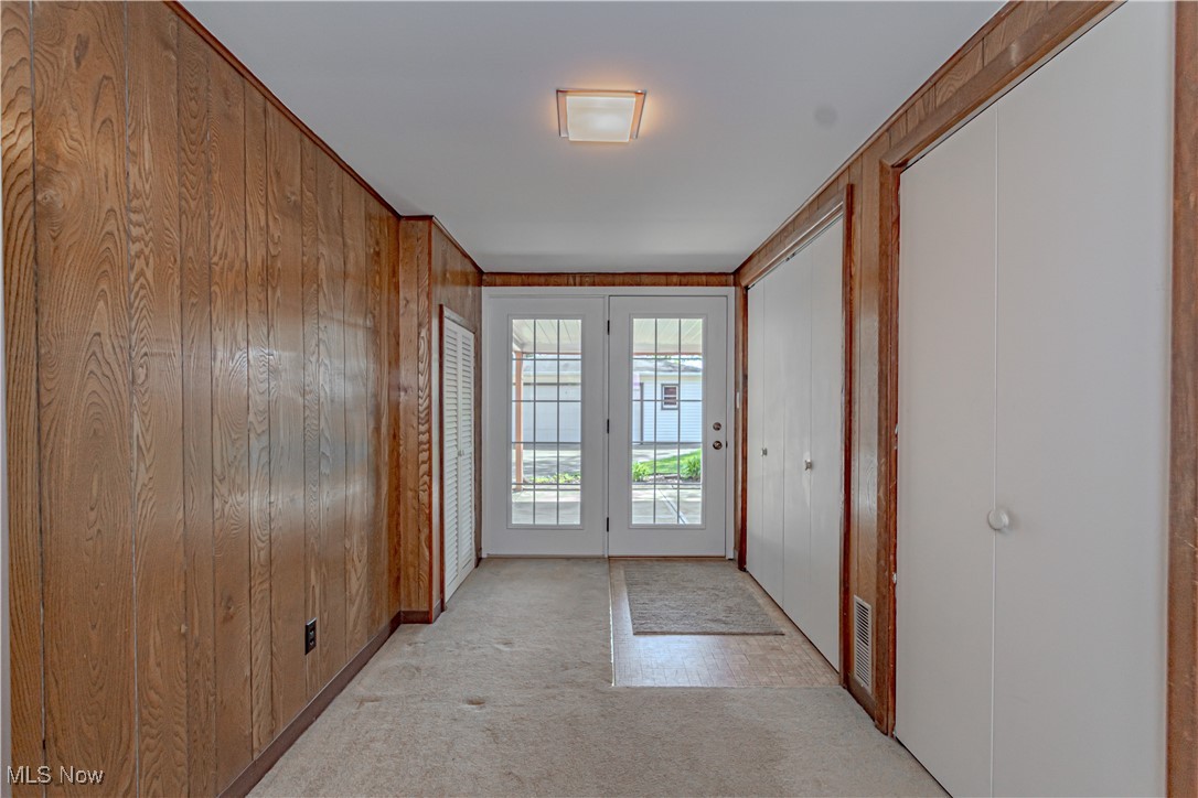 11153 Stoneham Road Cleveland, OH 44130 - Photo 18 of 18 Entryway with wooden walls, visible vents, and light carpet