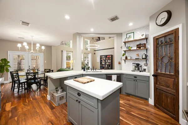 a kitchen with a sink appliances and wooden floor
