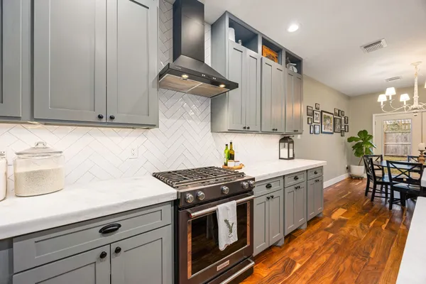 a kitchen with stainless steel appliances a stove a sink dishwasher and cabinets with wooden floor
