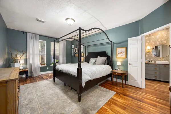 a bedroom with a large bed and a chandelier
