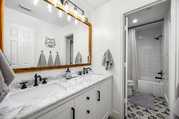 a bathroom with a granite countertop sink and a mirror