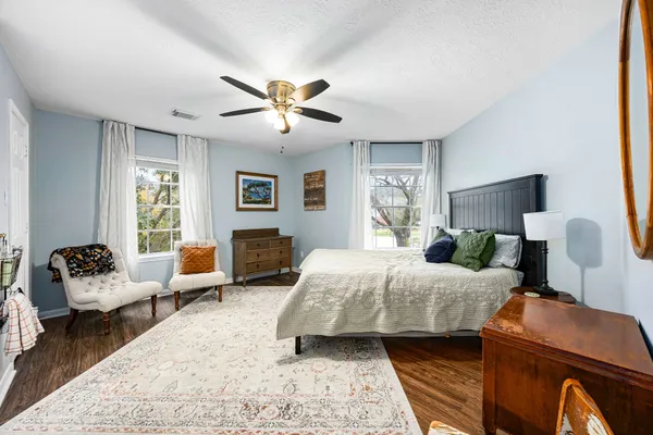 a bedroom with a bed couch chair and a window