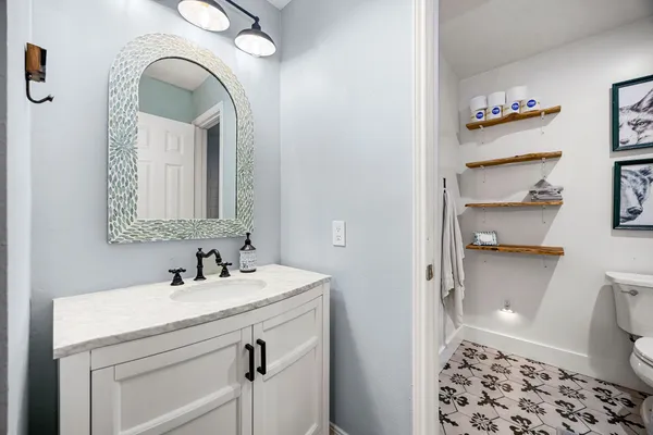 a bathroom with a sink a toilet and a mirror