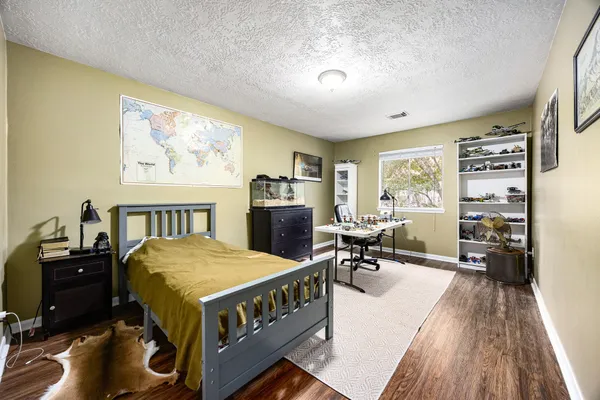 a bedroom with furniture and a wooden floor