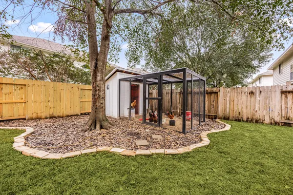 a front view of a house with a yard fountain and tree