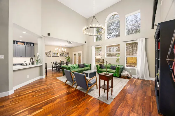 a view of a dining room with furniture a chandelier and wooden floor