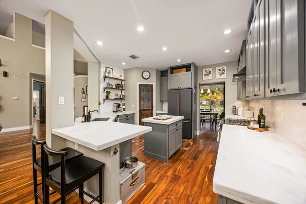 a large kitchen with kitchen island a large island a sink a stove and a chandelier