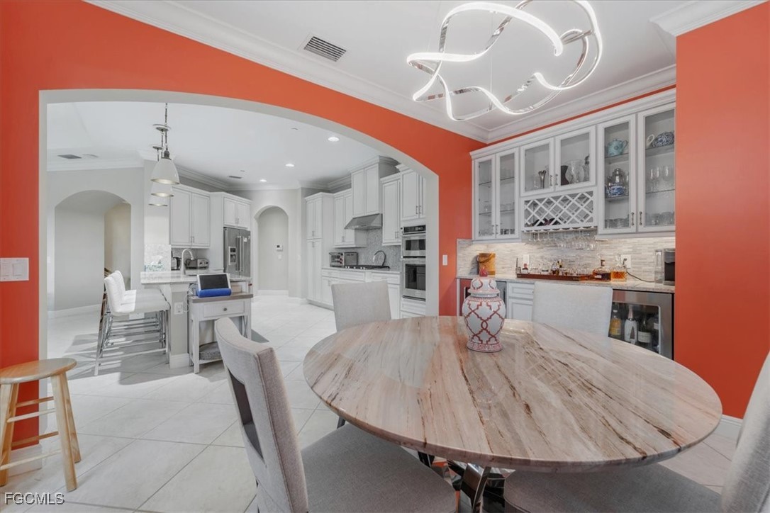 16432 Carrara Way, Unit 101 Naples, FL 34110 - Photo 14 of 50 a dining room with stainless steel appliances furniture large window and wooden floor