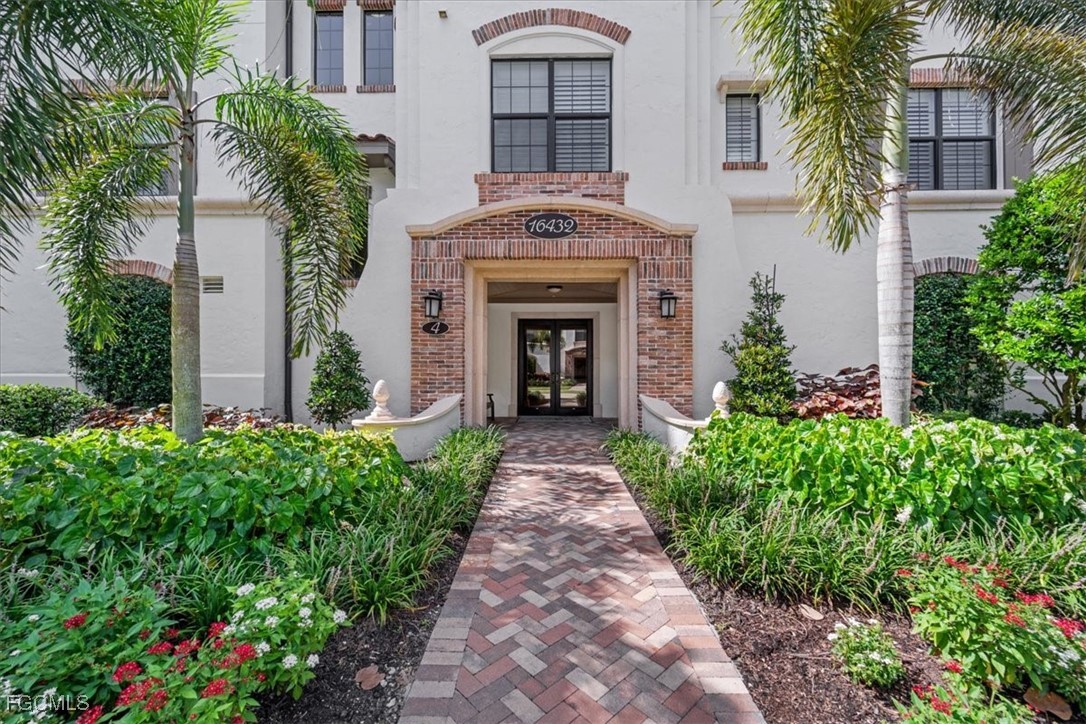 16432 Carrara Way, Unit 101 Naples, FL 34110 - Photo 2 of 50 a front view of a house with plants and garden