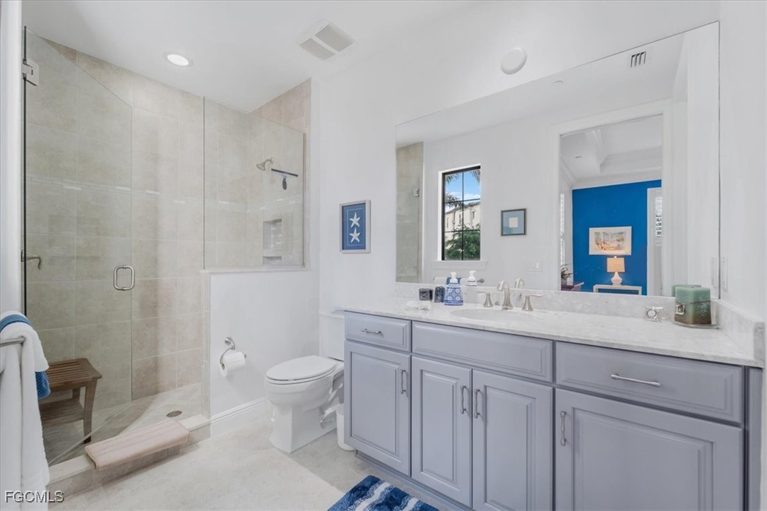 16432 Carrara Way, Unit 101 Naples, FL 34110 - Photo 31 of 50 a spacious bathroom with double sink a toilet a shower and a window
