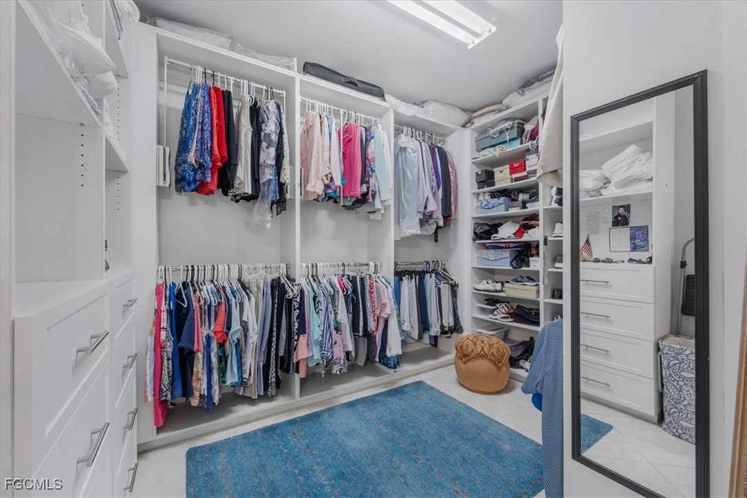 16432 Carrara Way, Unit 101 Naples, FL 34110 - Photo 35 of 50 a view of walk in closet with clothes and shoes