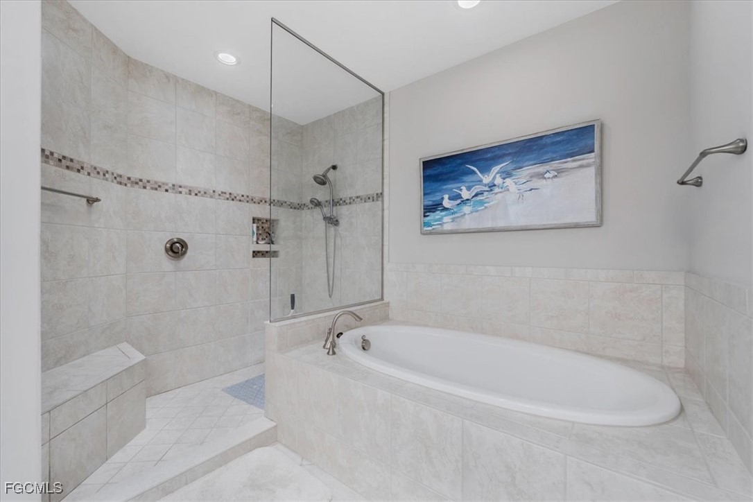 16432 Carrara Way, Unit 101 Naples, FL 34110 - Photo 37 of 50 a white bath tub sitting next to a shower