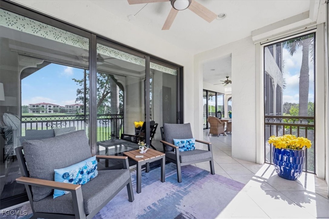 16432 Carrara Way, Unit 101 Naples, FL 34110 - Photo 42 of 50 a living room with furniture a chandelier and a table