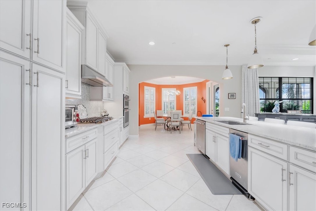 16432 Carrara Way, Unit 101 Naples, FL 34110 - Photo 6 of 50 a large kitchen with stainless steel appliances a lot of counter space and a sink