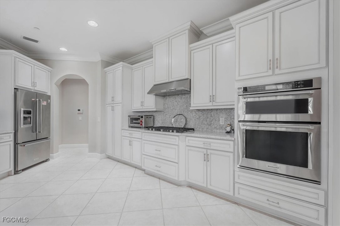 16432 Carrara Way, Unit 101 Naples, FL 34110 - Photo 8 of 50 a kitchen with granite countertop white cabinets and stainless steel appliances