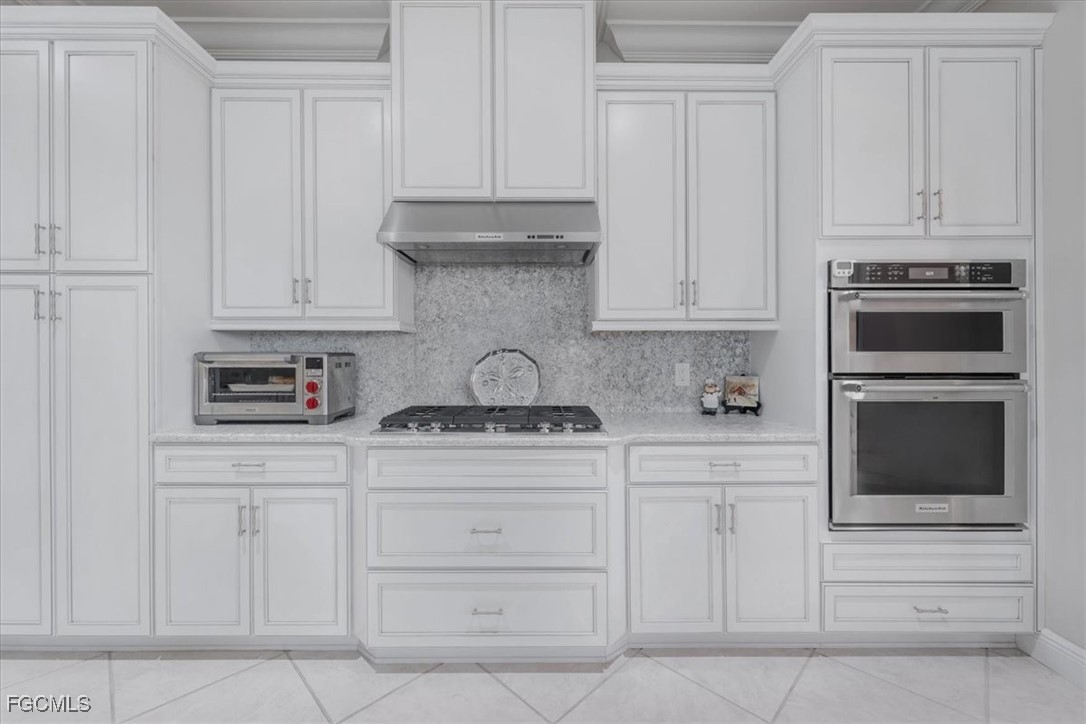 16432 Carrara Way, Unit 101 Naples, FL 34110 - Photo 9 of 50 a kitchen with white cabinets and a stove