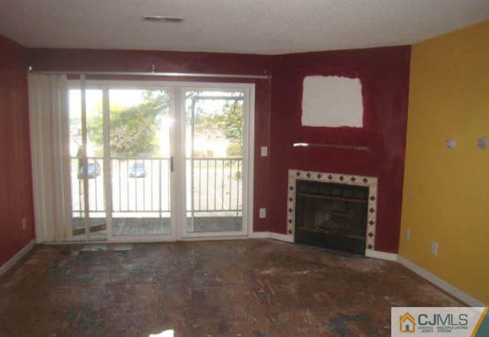 123 Edpas Road New Brunswick, NJ 08901 - Photo 2 of 9 a living room with a fireplace and a large window