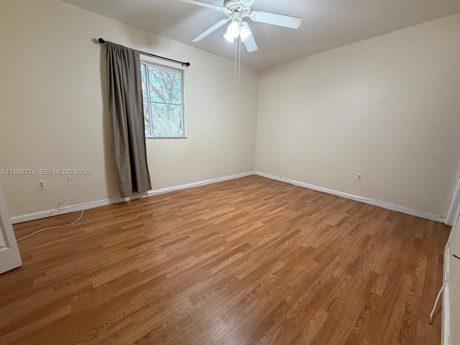 8246 Southwest 27th Street, Unit 103 Miramar, FL 33025 - Photo 14 of 17 wooden floor in an empty room with a window